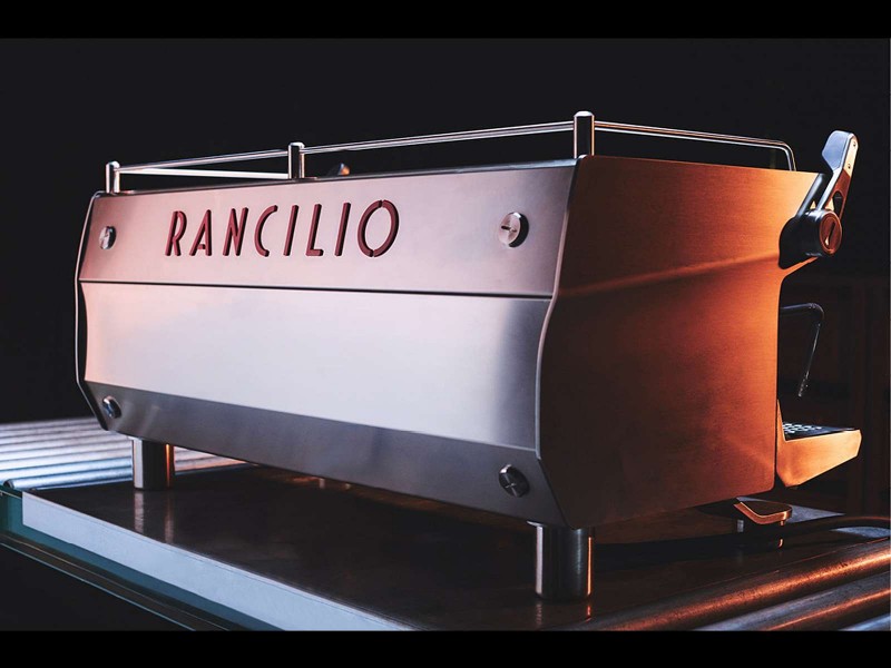 This image is a back-side view of the Rancilio Specialty RS1 3 group espresso machine in Stainless Steel.